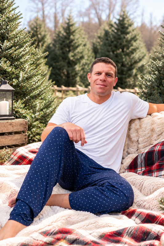 Man wearing navy Midnight Dot bamboo pajamas for Hanukkah and Christmas, featuring a classic white dot print and comfortable holiday sleepwear design