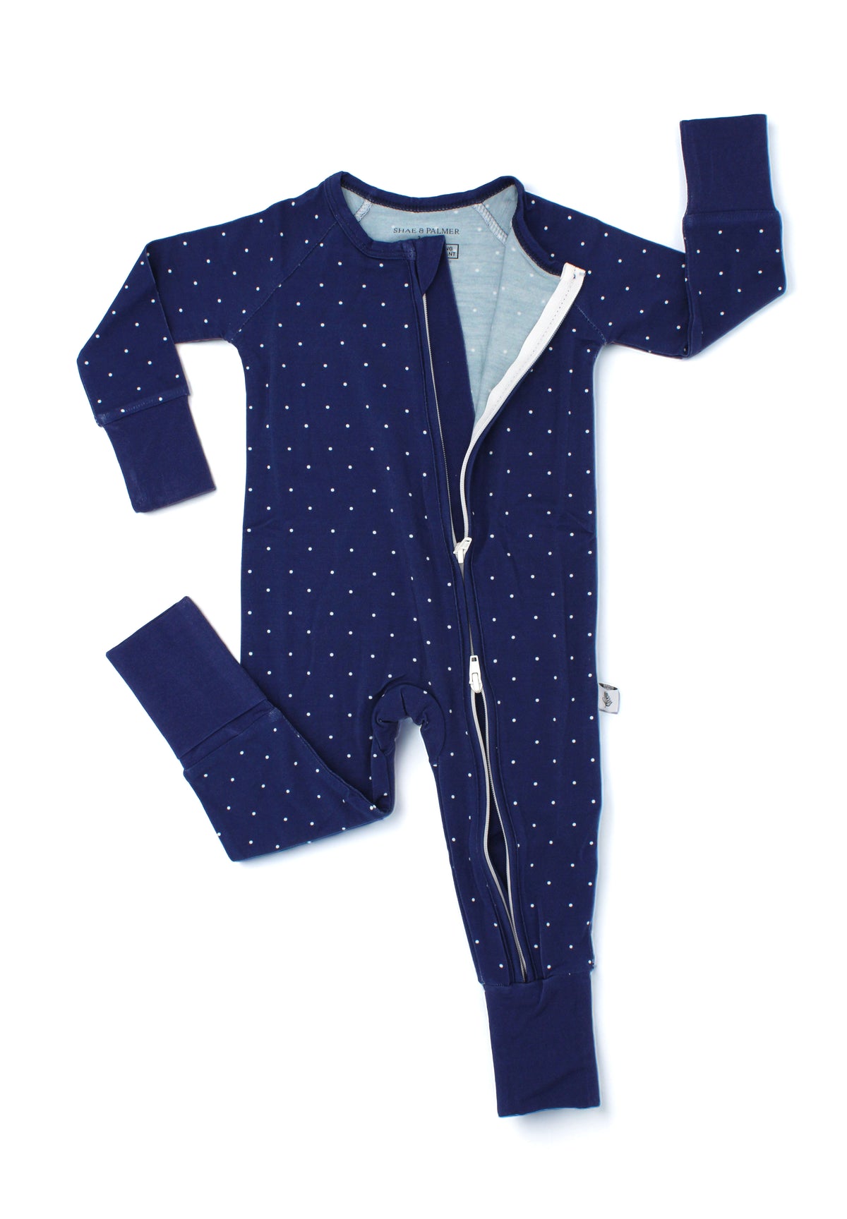Close-up flat lay of the Midnight Dot Collection bamboo baby romper by Shae & Palmer, showcasing the convenient double zipper closure and timeless navy dot print. Soft, breathable holiday baby pajamas designed for easy diaper changes and comfortable sleep, perfect for matching Hanukkah or Christmas family pajamas and festive holiday celebrations.