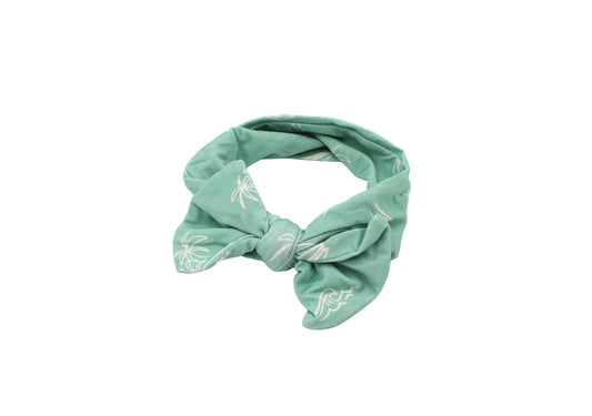 Close-up of baby wearing Shae & Palmer Surfside Dreams bamboo headband featuring palm tree, surfboard, and wave coastal print