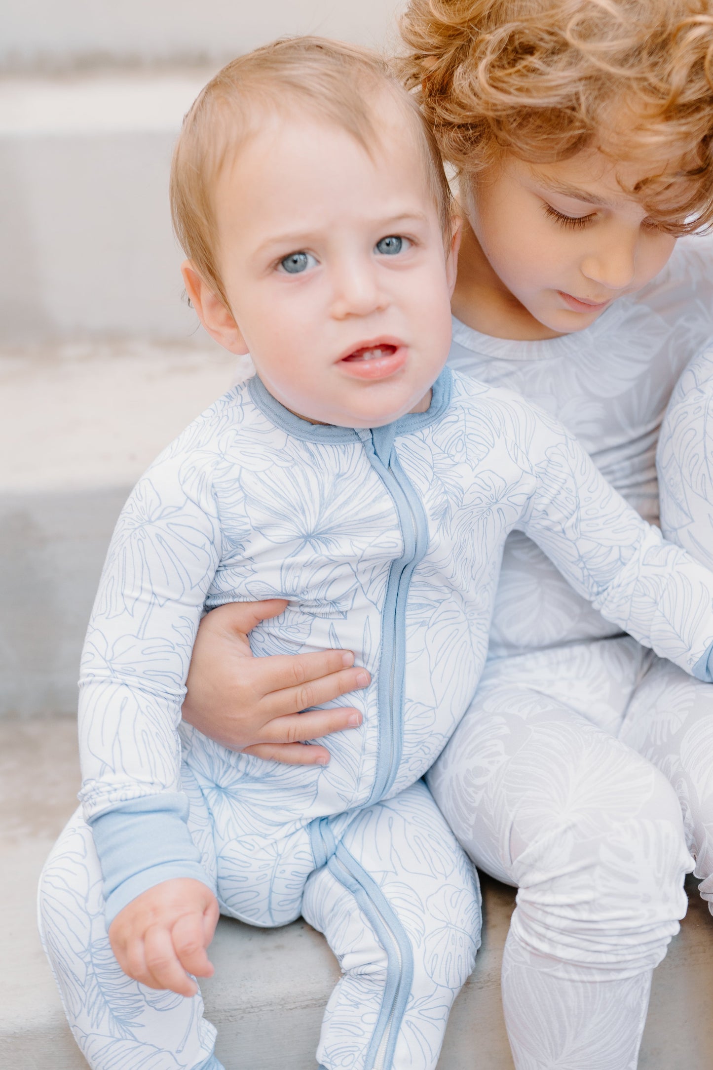 Shae & Palmer Tropical Bliss Collection - bamboo baby zip romper in Ocean Blue tropical floral print. Ultra-soft, breathable sleepwear with double zipper for easy diaper changes, perfect for summer-ready baby boys or girls.