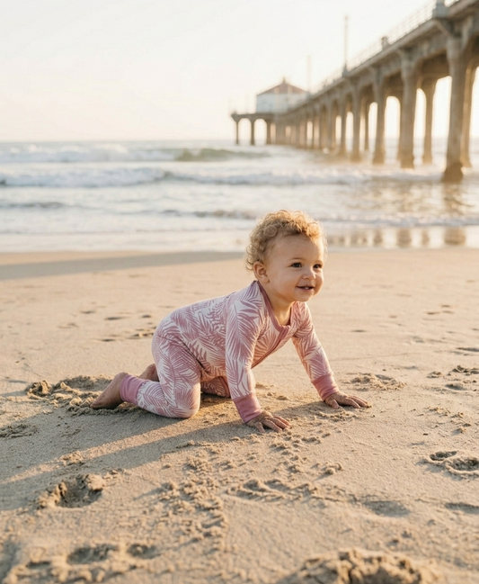 Baby wearing Shae & Palmer Cali Coastal bamboo pajamas on the beach — soft breathable sleepwear for newborns