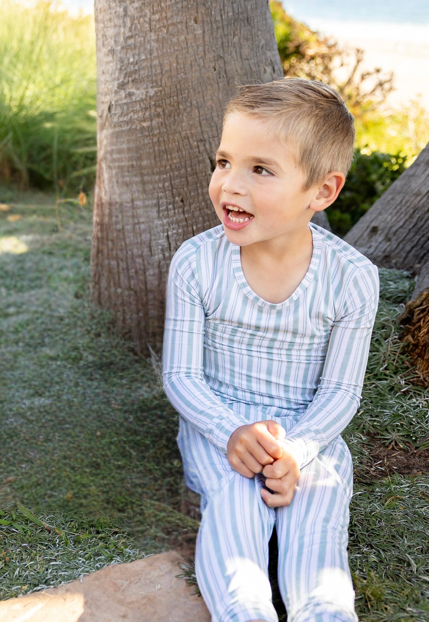 Toddler wearing Shae & Palmer Studio Stripe Green Haze bamboo pajamas featuring muted green painterly stripes, buttery-soft breathable bamboo fabric, and a cozy two-piece design for sleep and play.