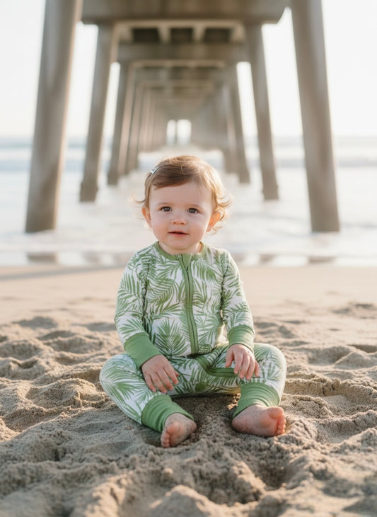 Baby wearing Cali Coastal bamboo pajamas by Shae & Palmer, breathable temperature-regulating fabric, palm leaf print romper