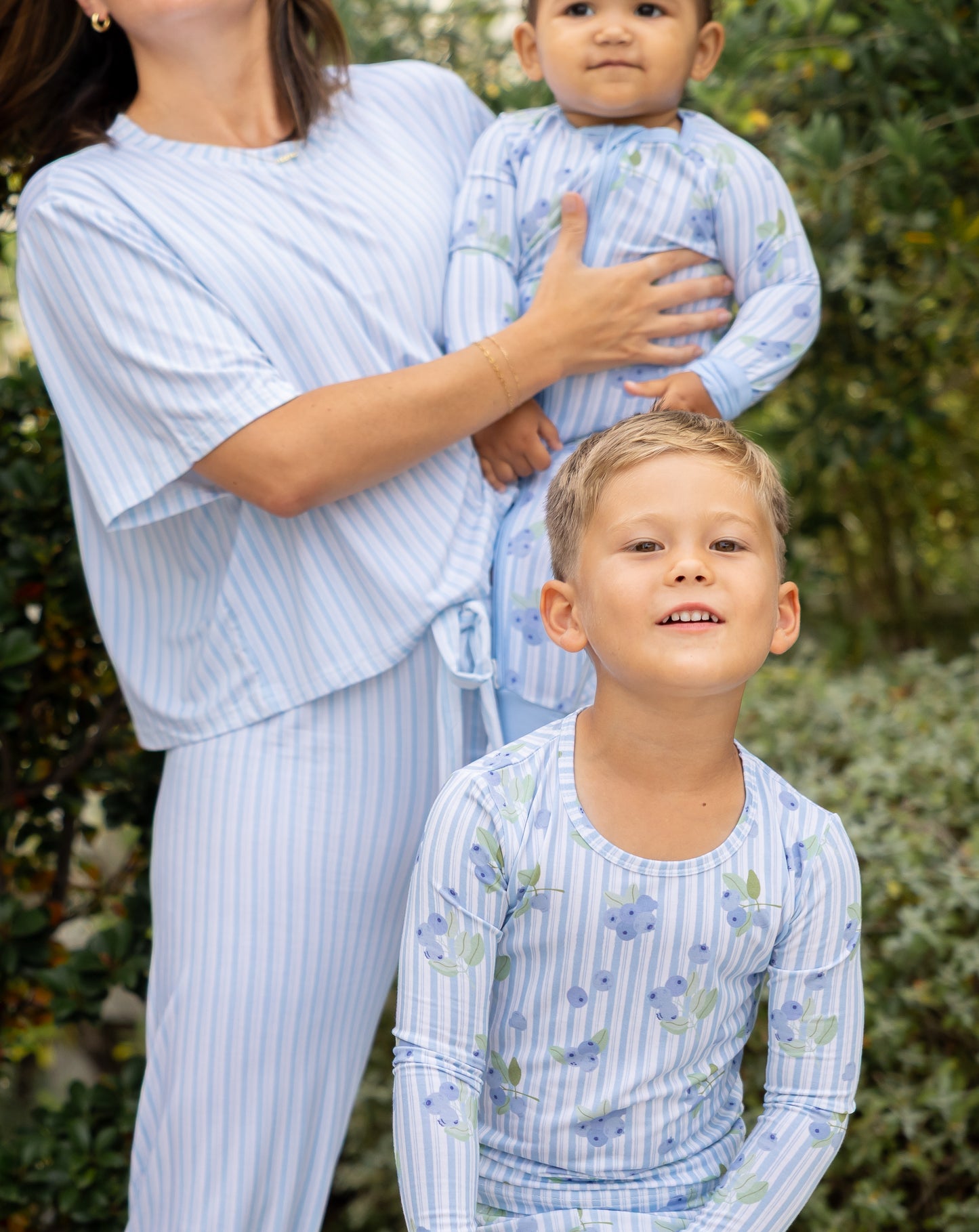 Mom, baby, and kid boy in matching Blueberry Lane blue striped bamboo pajamas from Shae & Palmer's mommy-and-me Market Fresh collection