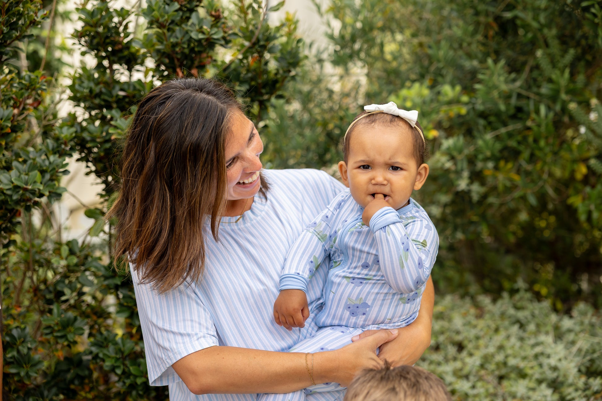 Mom in Blueberry stripe bamboo pajamas smiling at her baby in matching print, from Shae & Palmer's mommy-and-me Market Fresh collection.