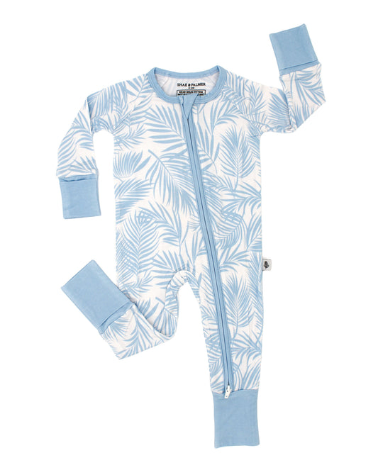 Flat lay of Cali Coastal Baby Blue bamboo baby romper featuring palm leaf print, lightweight and temperature-regulating baby sleepwear