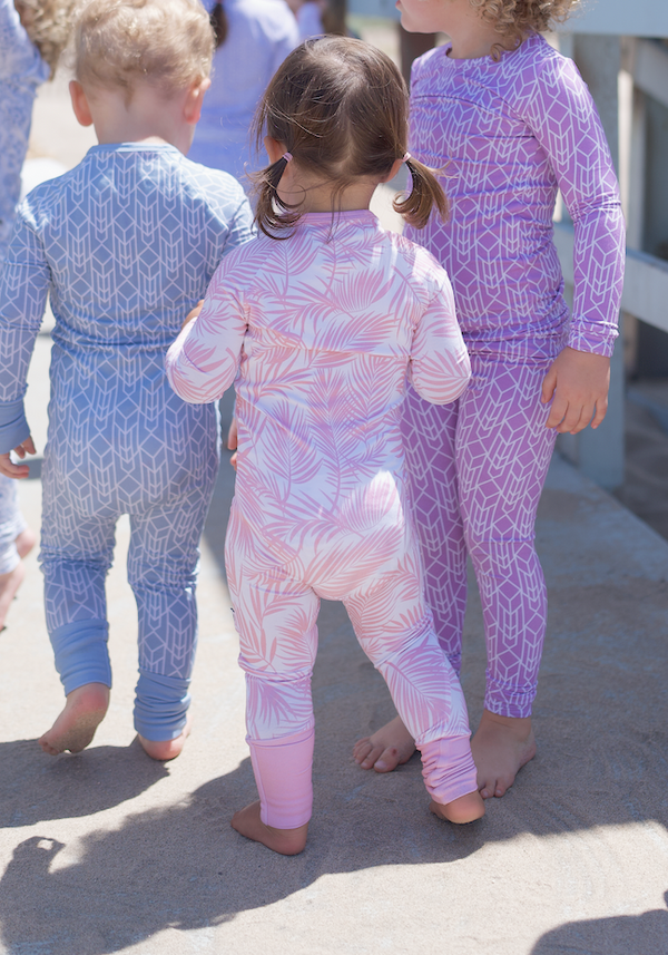 Shae & Palmer Cali Coastal Collection - bamboo baby zip romper in Pink palm leaf print. Ultra-soft, breathable zip-up pajamas with double zipper for easy diaper changes, perfect for stylish baby girls.