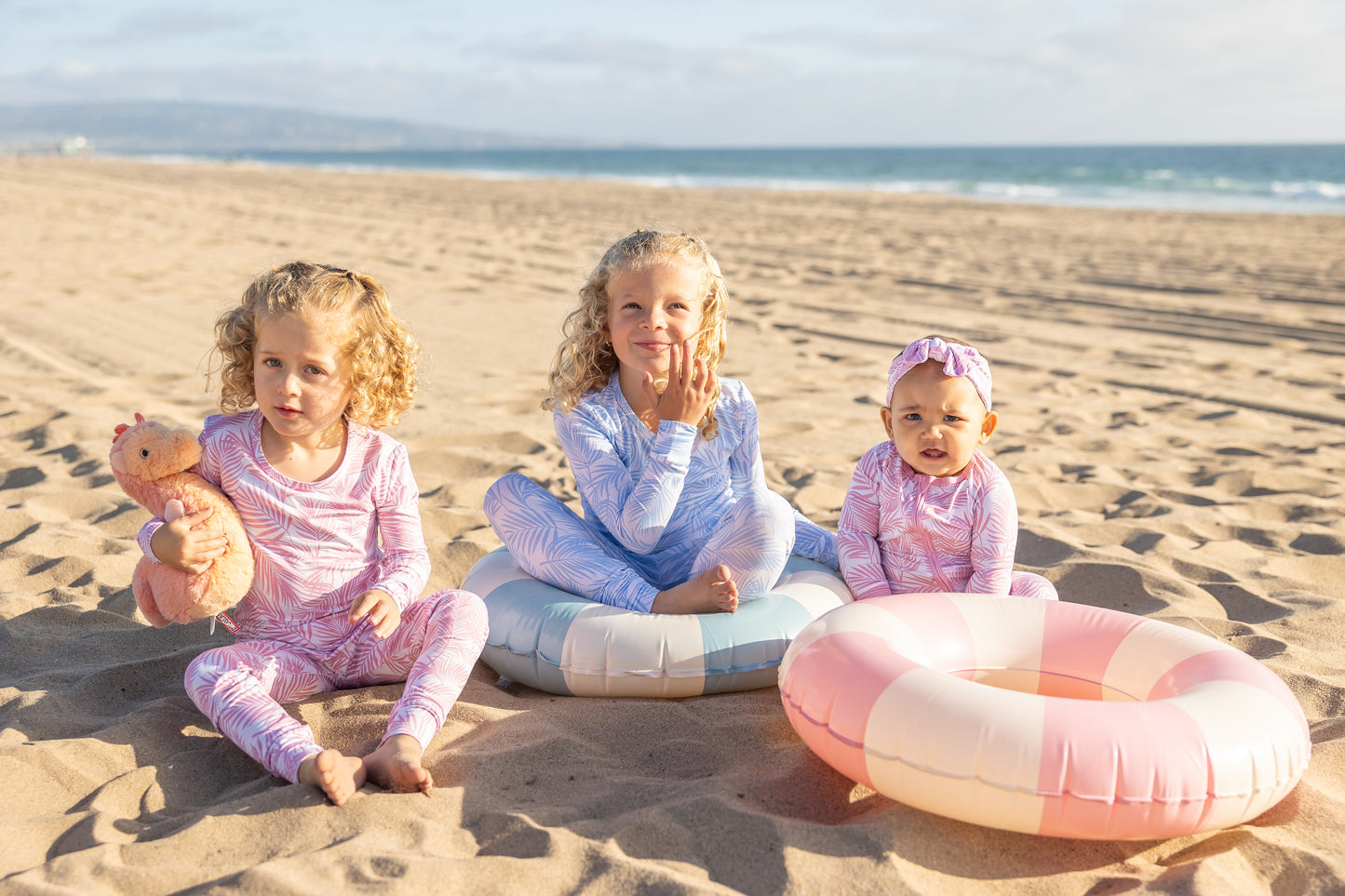 Baby and toddler wearing matching Cali Coastal Pink bamboo pajamas featuring soft tropical palm leaf print by Shae & Palmer