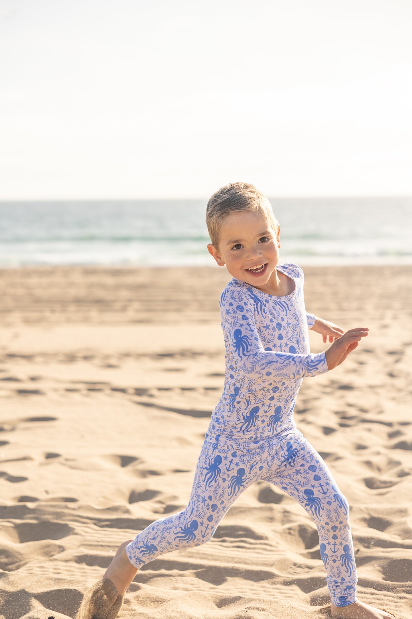 Big kids wearing Shae & Palmer Hidden Ocean Treasures bamboo pajamas featuring ocean-inspired seashells, octopus, and anchor print