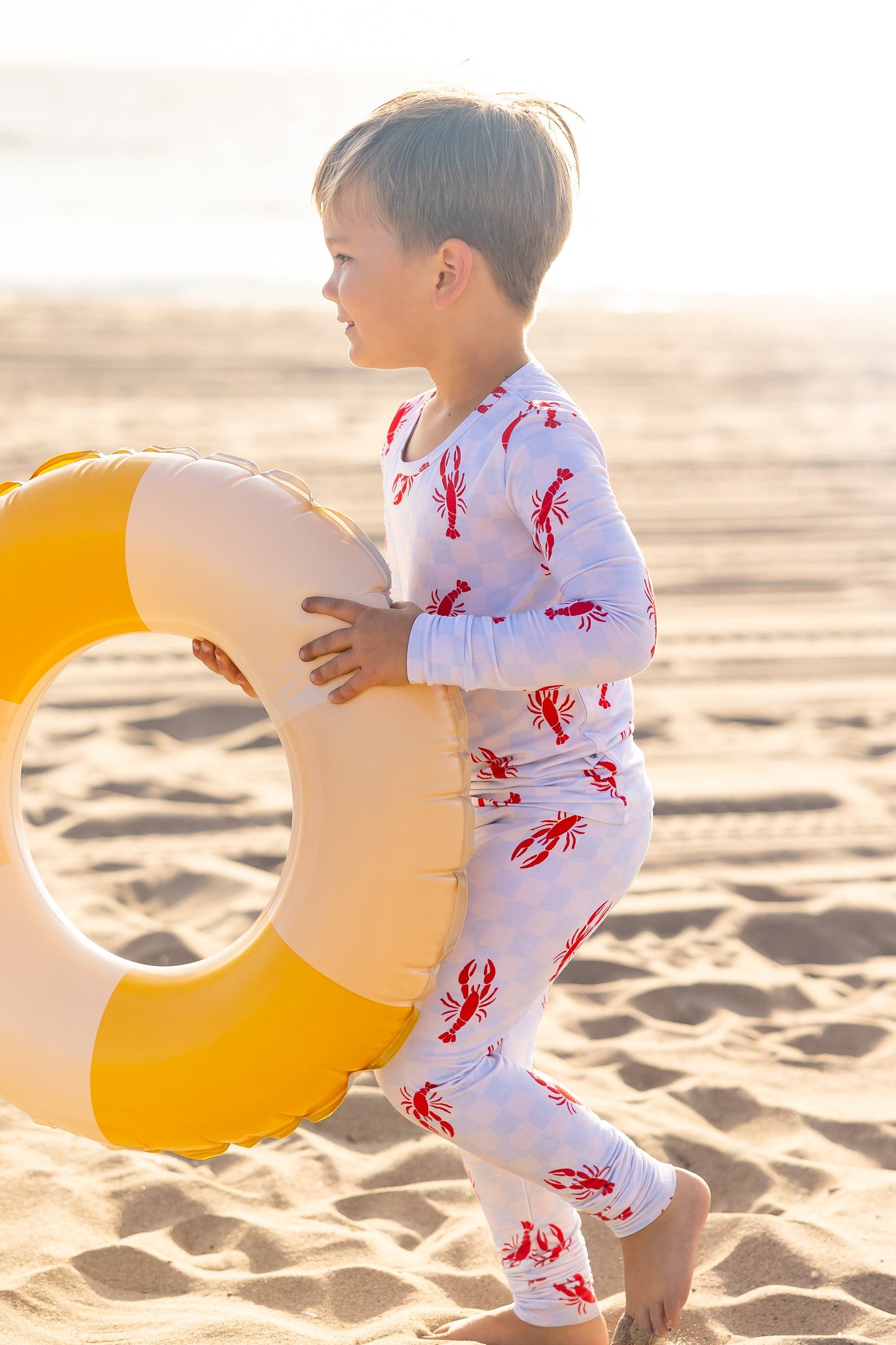 Toddler bamboo pajamas in the Lobster Splash print featuring playful red lobsters on a soft blue checkered background by Shae & Palmer
