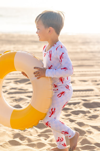 Toddler bamboo pajamas in the Lobster Splash print featuring playful red lobsters on a soft blue checkered background by Shae & Palmer