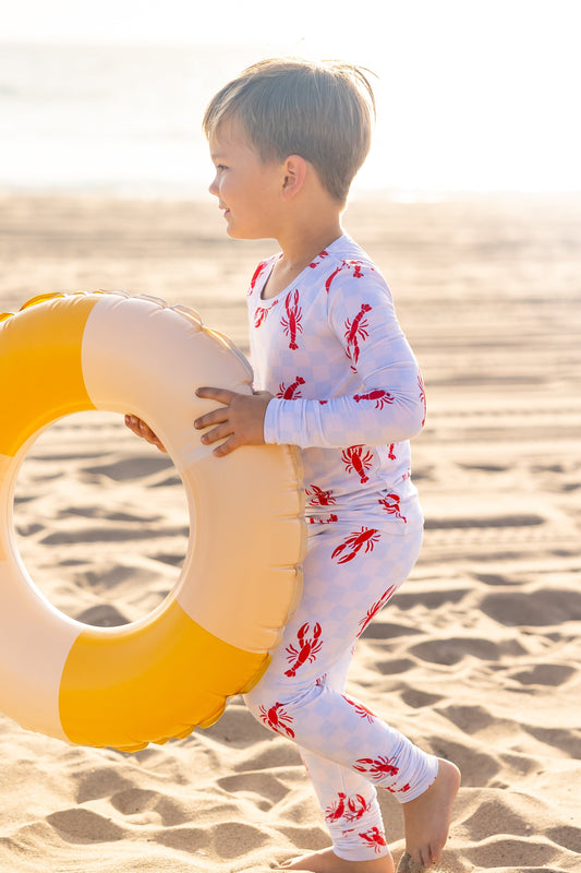 Toddler bamboo pajamas in the Lobster Splash print featuring playful red lobsters on a soft blue checkered background by Shae & Palmer