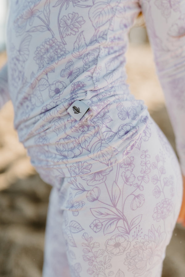 Shae & Palmer eco-conscious bamboo baby romper in Botanical Amethyst, a floral zippered pajama made with sustainable bamboo material, designed for soft, breathable comfort and everyday wear for babies and toddlers.