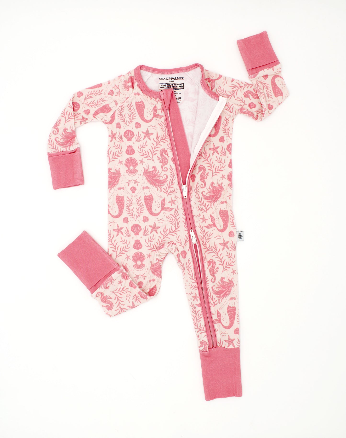 Baby wearing Mermaid Cove bamboo pajamas with mermaid and seashell print, soft breathable baby sleepwear designed for comfort and movement