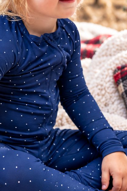 Close-up of Midnight Dot navy bamboo pajama fabric with a delicate white polka dot print, soft breathable holiday sleepwear for Hanukkah and Christmas