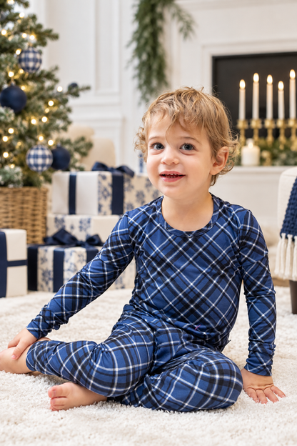 Toddler wearing navy blue Midnight Plaid bamboo pajamas, perfect for Christmas and Hanukkah holiday celebrations