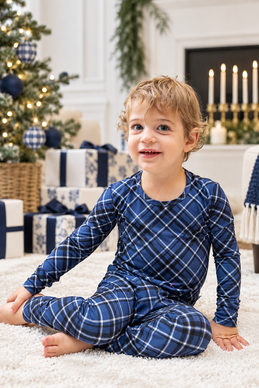 Toddler wearing navy blue Midnight Plaid bamboo pajamas, perfect for Christmas and Hanukkah holiday celebrations