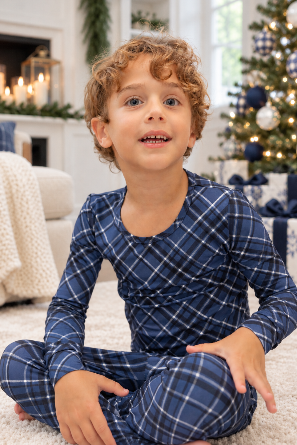 Big kid wearing navy blue Midnight Plaid bamboo pajamas in a cozy Christmas or hanukkah living room with holiday tree and gifts