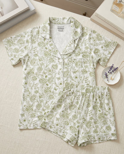 Woman wearing Botanical Moss Green bamboo pajamas by Shae & Palmer, breathable short sleeve button-up top and shorts set