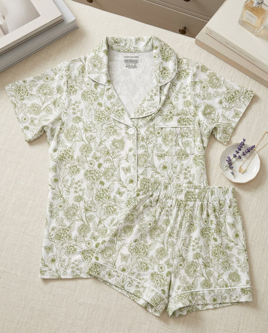 Woman wearing Botanical Moss Green bamboo pajamas by Shae & Palmer, breathable short sleeve button-up top and shorts set