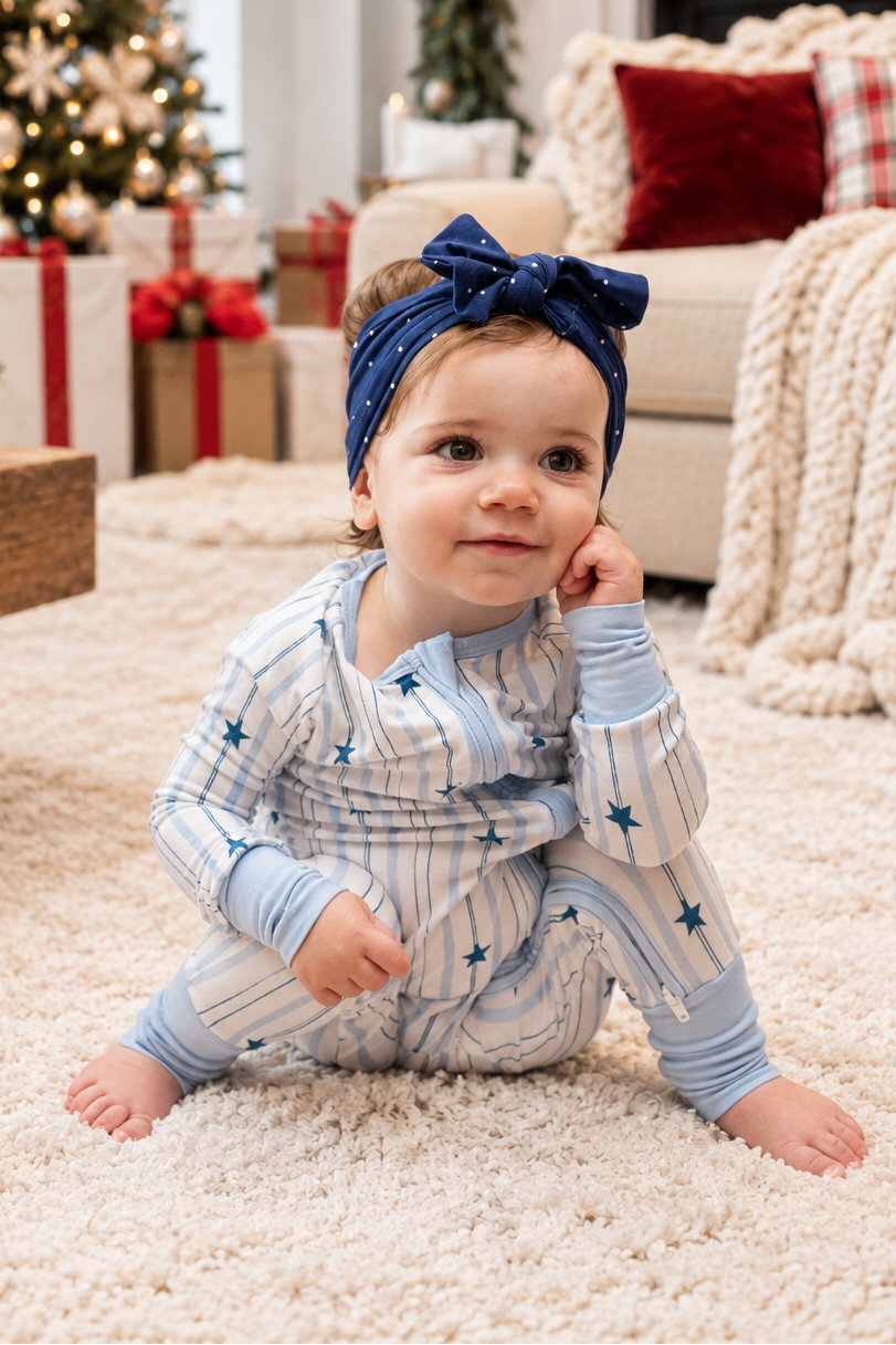 Baby wearing North Star blue striped bamboo pajamas with navy stars for Hanukkah and Christmas