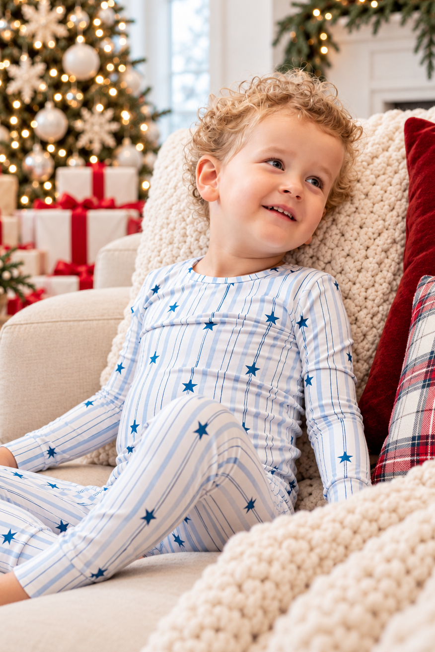 Boy wearing North Star blue striped bamboo pajamas with navy stars, perfect for Christmas, Hanukkah, and matching family holiday pajamas.