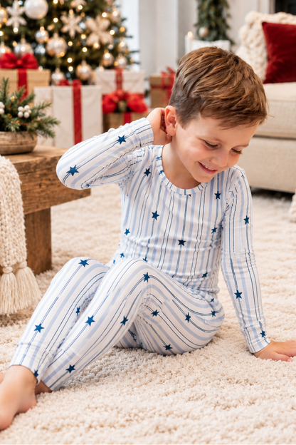 Big kid wearing North Star blue striped bamboo pajamas with navy stars, perfect for Christmas and Hanukkah
