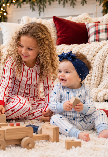 Baby in North Star pajamas with toddler in Ribbon Stripe bamboo pajamas for matching Christmas and Hanukkah holiday sleepwear