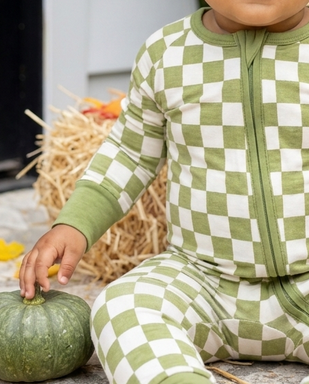 Close-up of the buttery-soft olive green and ivory checkered bamboo fabric on Orchard Checkered baby pajamas.