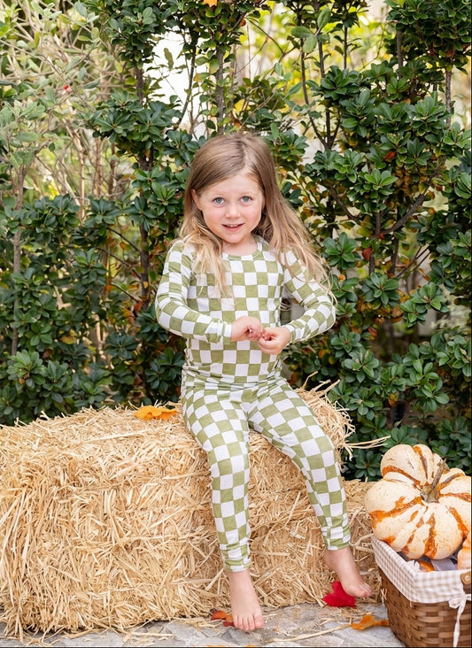 Toddler wearing Orchard Checkered bamboo pajamas in a soft olive green and ivory checkered fall print.