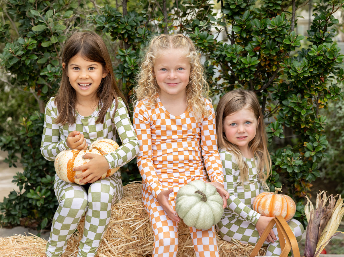 Big kids enjoying a cozy moment in soft Orchard Checkered green and ivory bamboo pajamas.