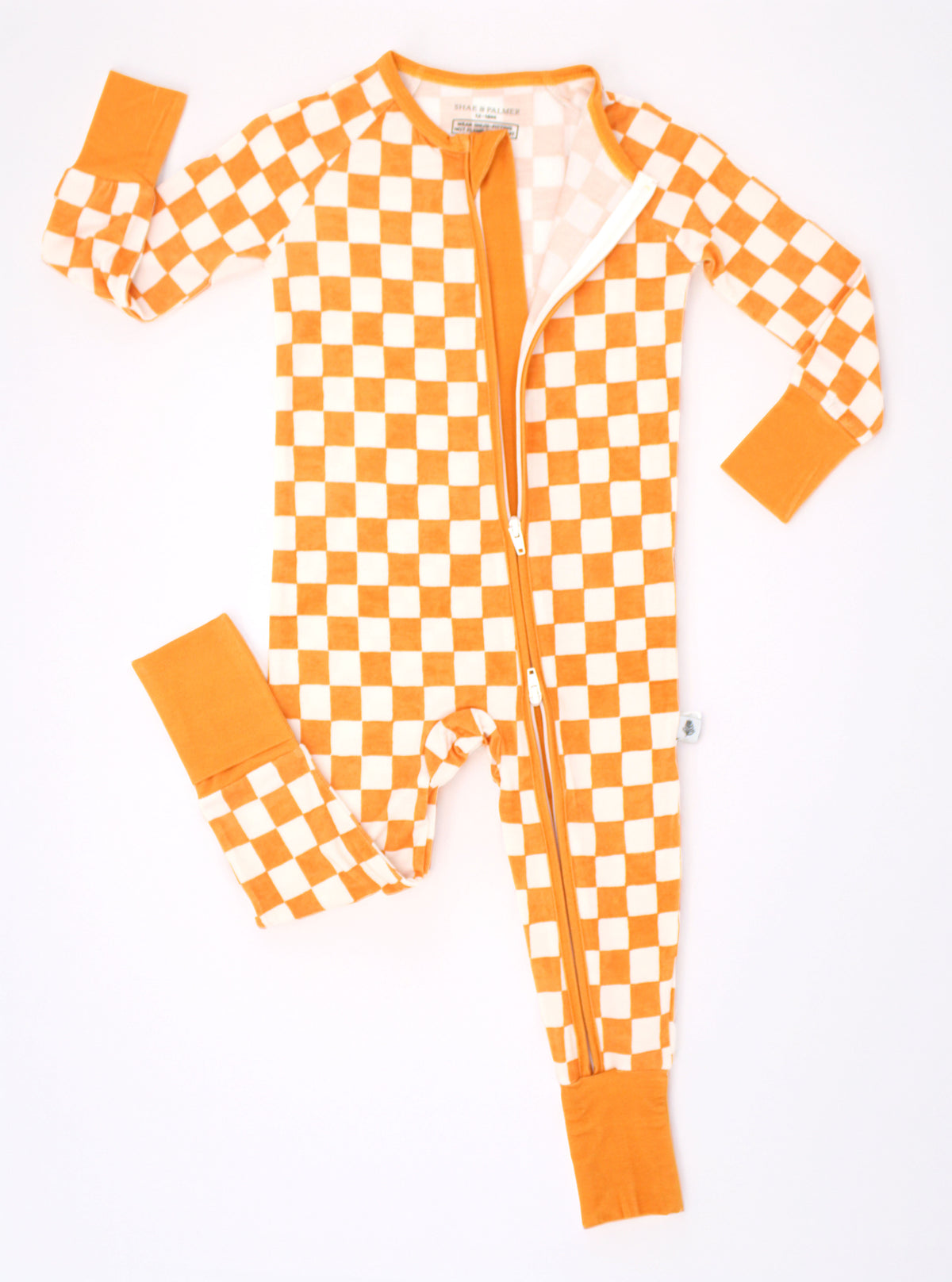 Pumpkin Patch baby bamboo pajamas shown in a flat lay with a convenient front zipper and orange and ivory checkered print.
