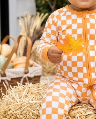 close-up of the orange and ivory checkered Pumpkin Patch print on soft bamboo baby pajamas.
