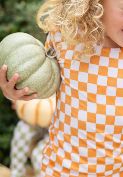 Close-up of the orange and ivory checkered print on Pumpkin Patch bamboo toddler pajamas.