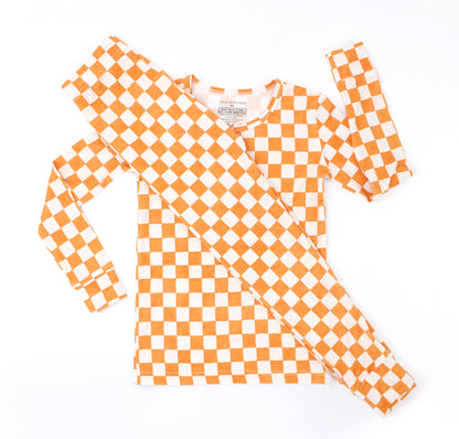 Pumpkin Patch toddler bamboo pajamas in a warm orange and ivory checkered print, shown in a flat lay.