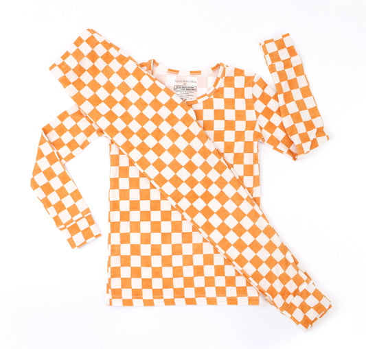 Pumpkin Patch toddler bamboo pajamas in a warm orange and ivory checkered print, shown in a flat lay.