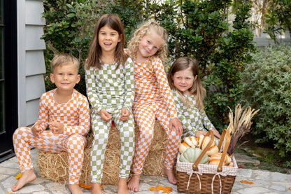 Child wearing cozy Pumpkin Patch bamboo toddler pajamas in a classic orange checkered fall print.
