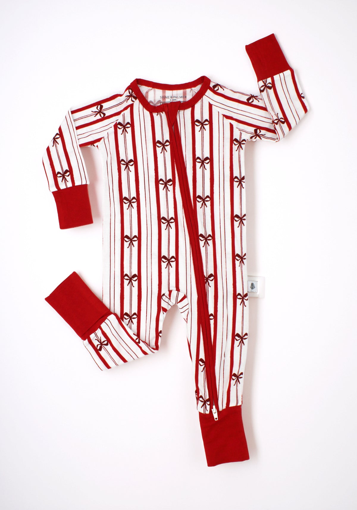 Ribbon Stripe bamboo baby romper by Shae & Palmer featuring classic red and ivory stripes with delicate bows. Soft, breathable Christmas baby pajamas perfect for holiday family photos, cozy winter nights, and matching family pajama sets.