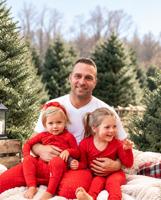 Dad and kids wearing matching Ruby Dot red Christmas pajamas for family holiday celebrations