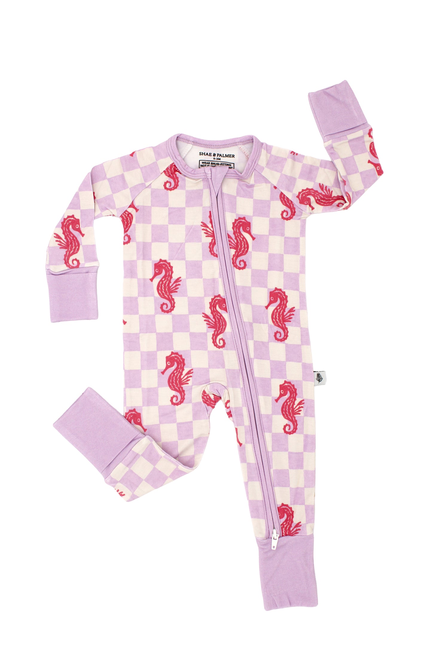Baby wearing Seahorse Splash bamboo pajamas in coral pink seahorse print on soft lavender checkerboard, luxury breathable sleepwear for infants