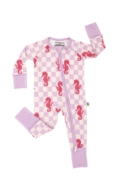 Baby wearing Seahorse Splash bamboo pajamas in coral pink seahorse print on soft lavender checkerboard, luxury breathable sleepwear for infants