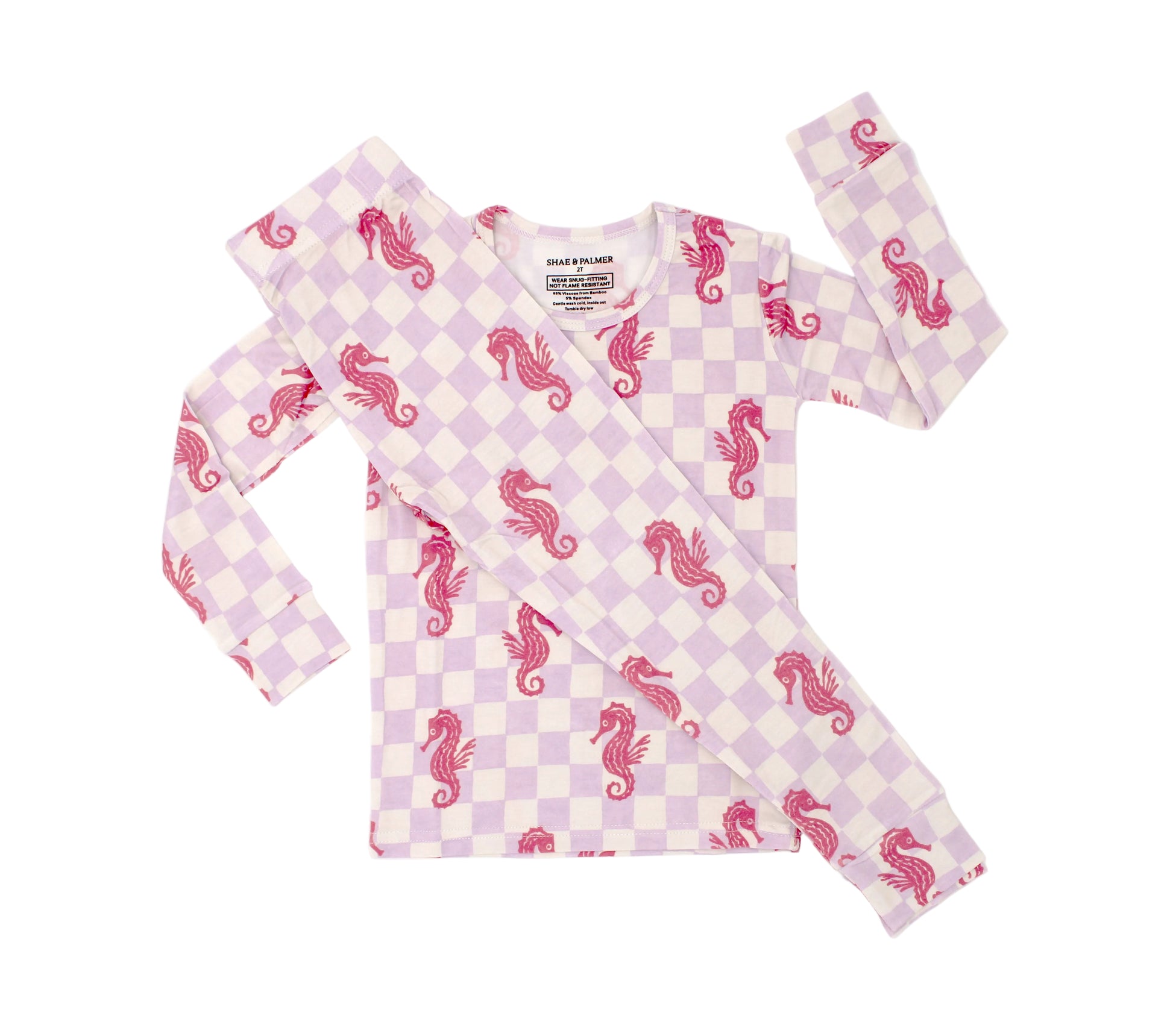 Toddler wearing Seahorse Splash bamboo pajamas with lavender checkered pattern and coral seahorse print front view