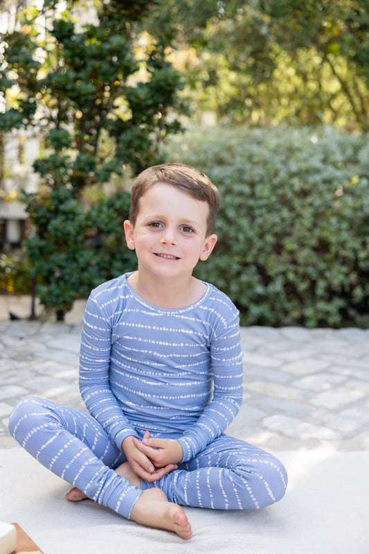 Big kid boy in Blue Raspberry Stripe bamboo pajama set sitting outdoors
