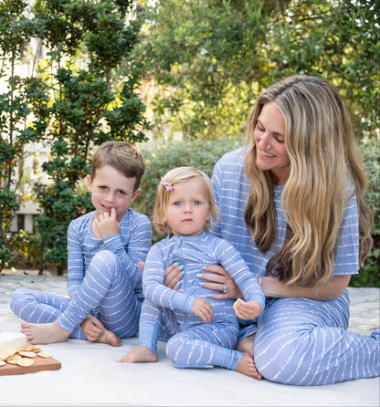 Mom and kids in matching Blue Raspberry Stripe bamboo pajamas at a picnic