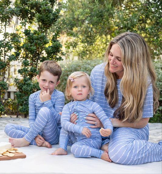 Mom and kids in matching Blue Raspberry Stripe bamboo pajamas at a picnic