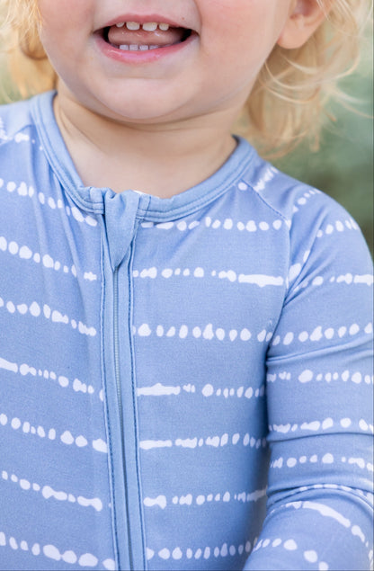 Close-up of toddler in Blue Raspberry Stripe bamboo zip romper with soft breathable fabric