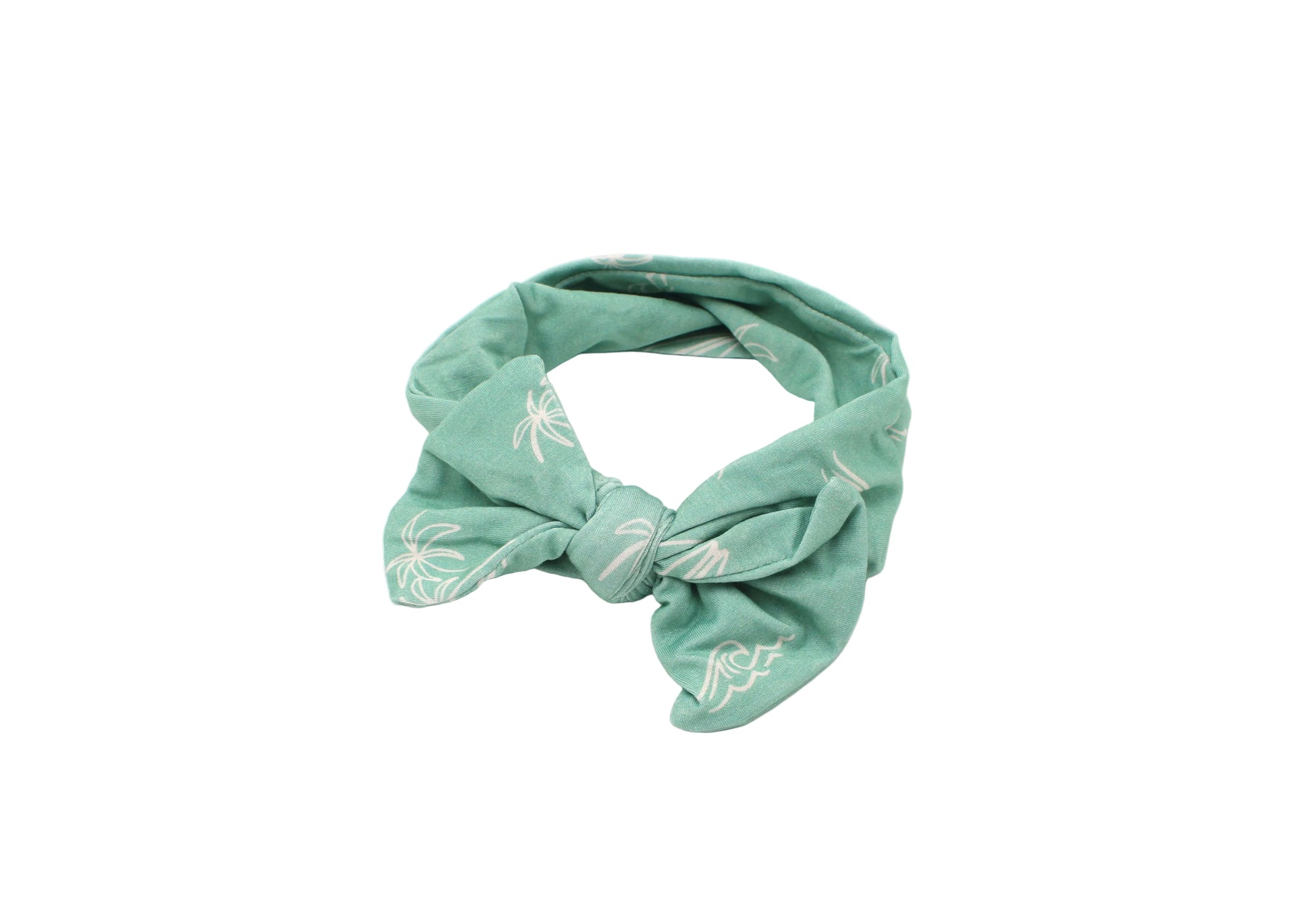 Close-up of baby wearing Shae & Palmer Surfside Dreams bamboo headband featuring palm tree, surfboard, and wave coastal print