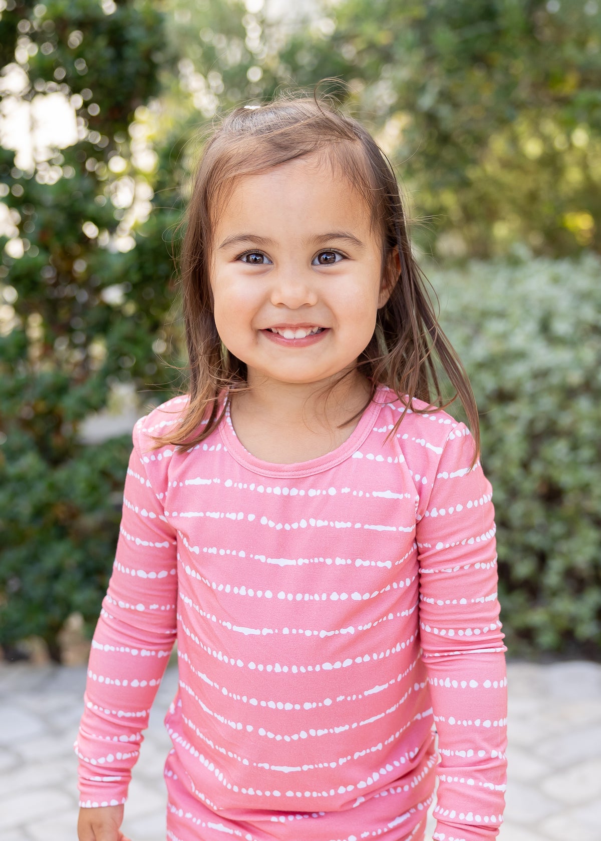 kids girl smiling in Watermelon Blush Stripe bamboo pajama set outdoors