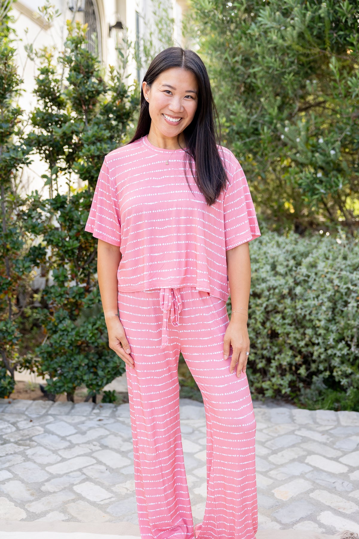 Woman in Watermelon Blush Stripe bamboo pajama set, boxy top and wide-leg pants