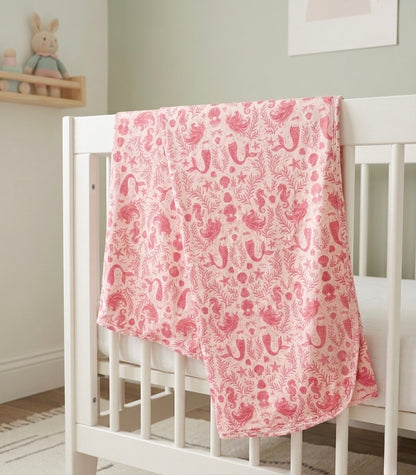 Lightweight bamboo baby blanket from Shae & Palmer in the Mermaid Cove print, featuring playful mermaids and seaside illustrations.